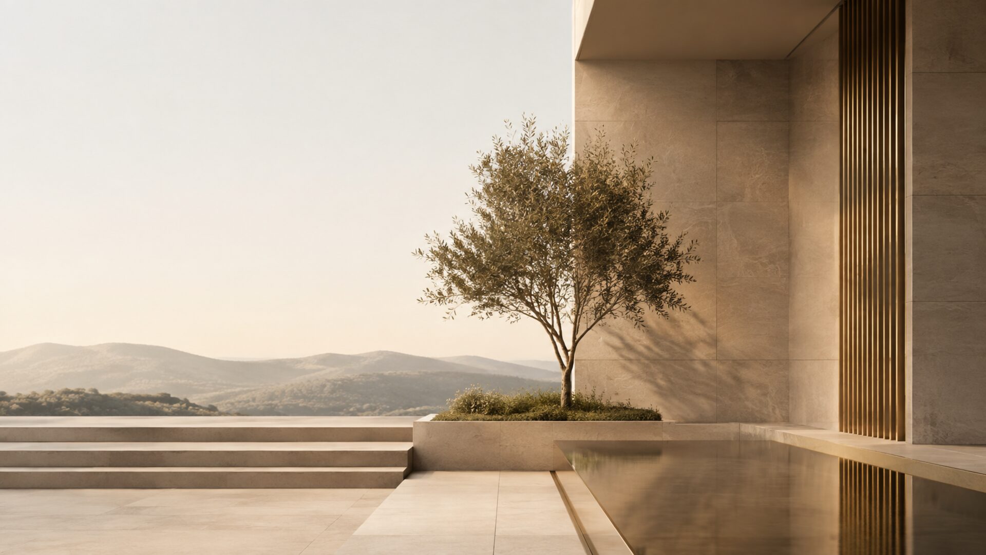 Courtyard of a stone building with an olive tree overlooking distant hills at dusk